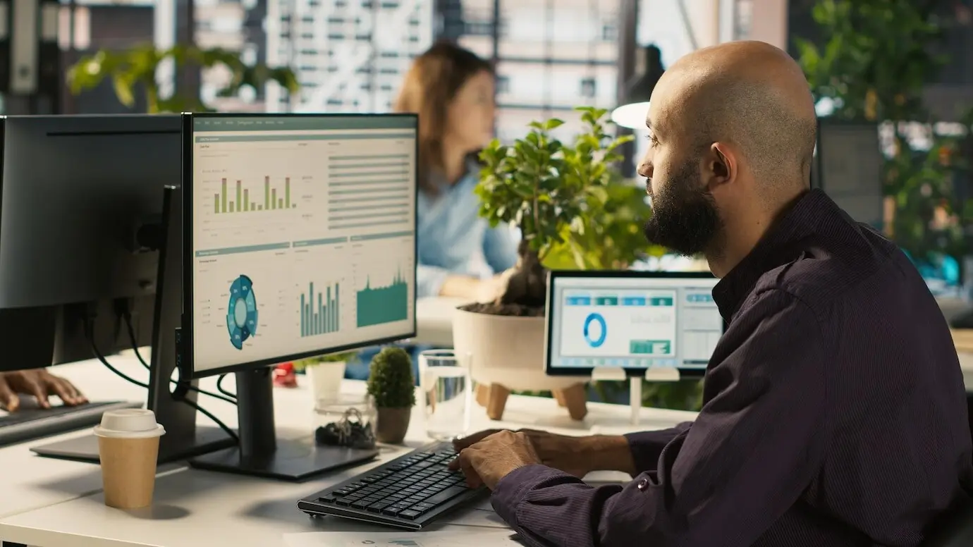 Сотрудник за офисным столом редактирует документы на настольном компьютере.