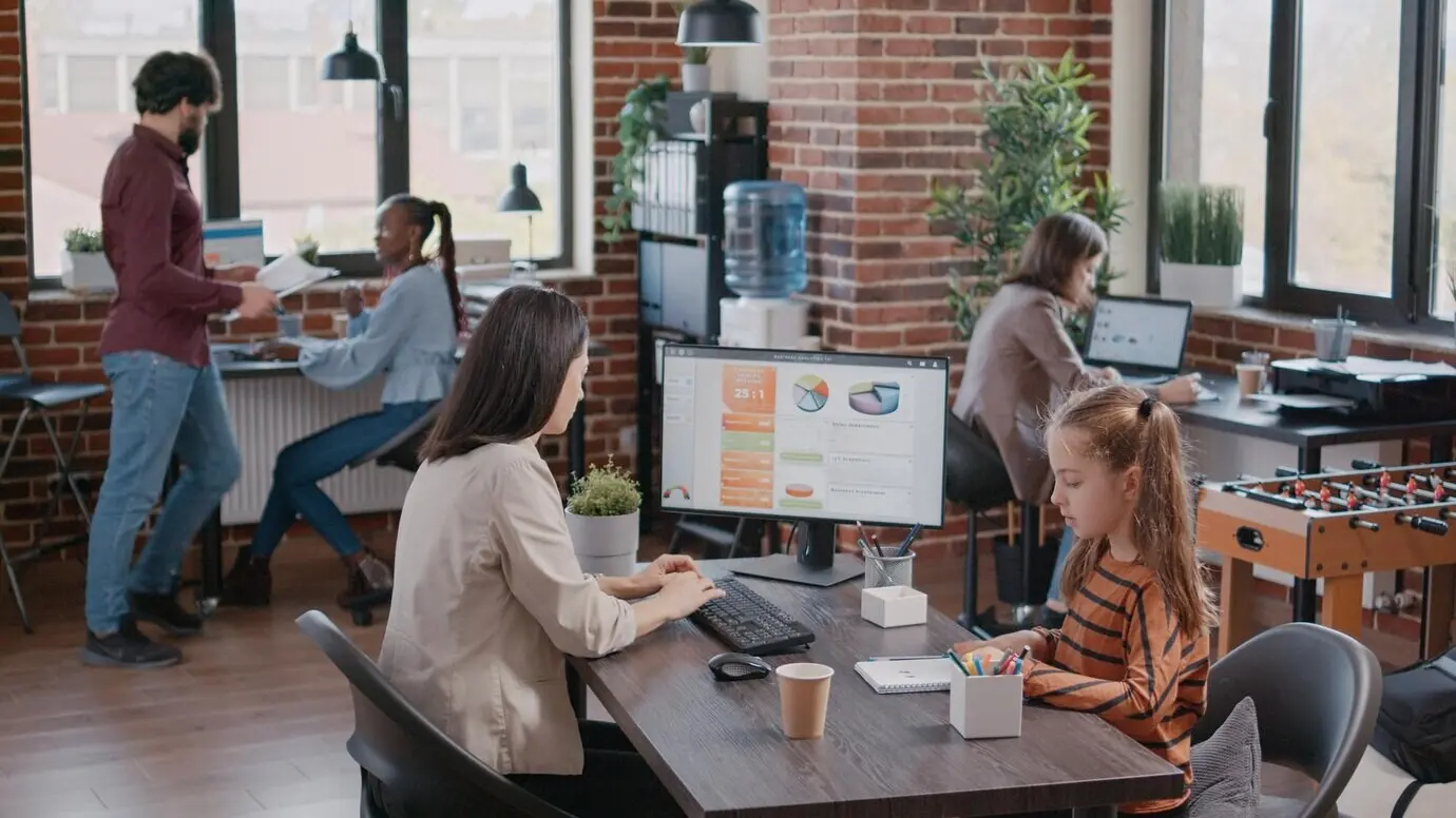 Заскучавшая дочь громко шумит в офисе, пока мать и коллеги пытаются работать и выполнять задания. Мать-одиночка испытывает стресс из‑за того, что ребёнок мешает окружающим.